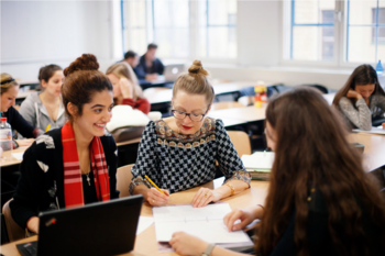 Gruppe weiblicher Studierende sitzen in Seminarraum